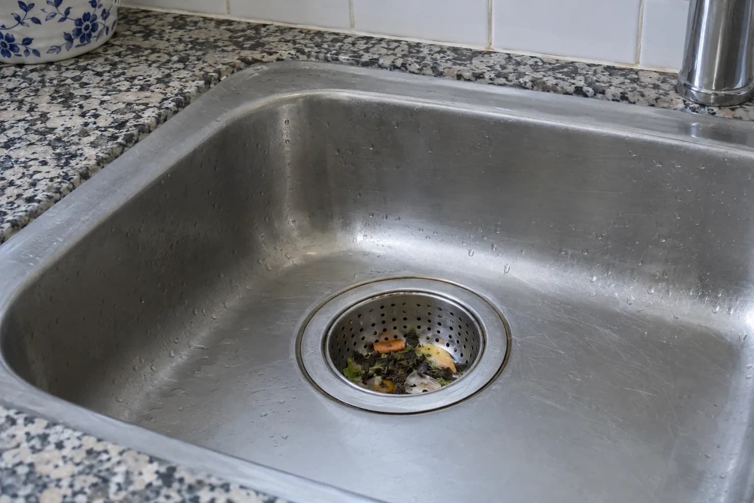 Ralo de um lava-loiça de aço inoxidável com um cesto perfurado a reter restos de comida